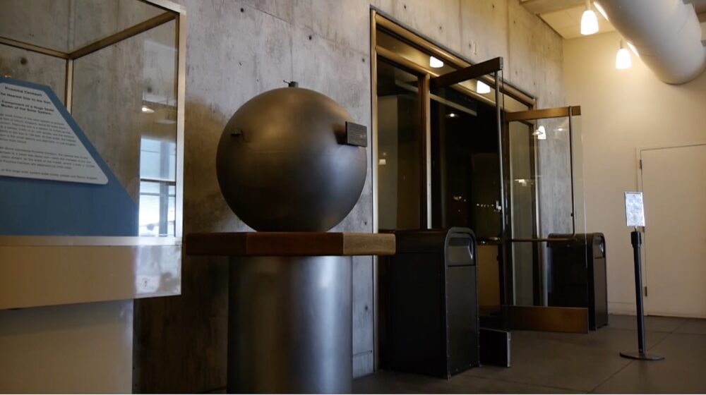 Large round bronze object on pedestal in the lobby of the Giffith Park Observatory. Object is a time capsule.