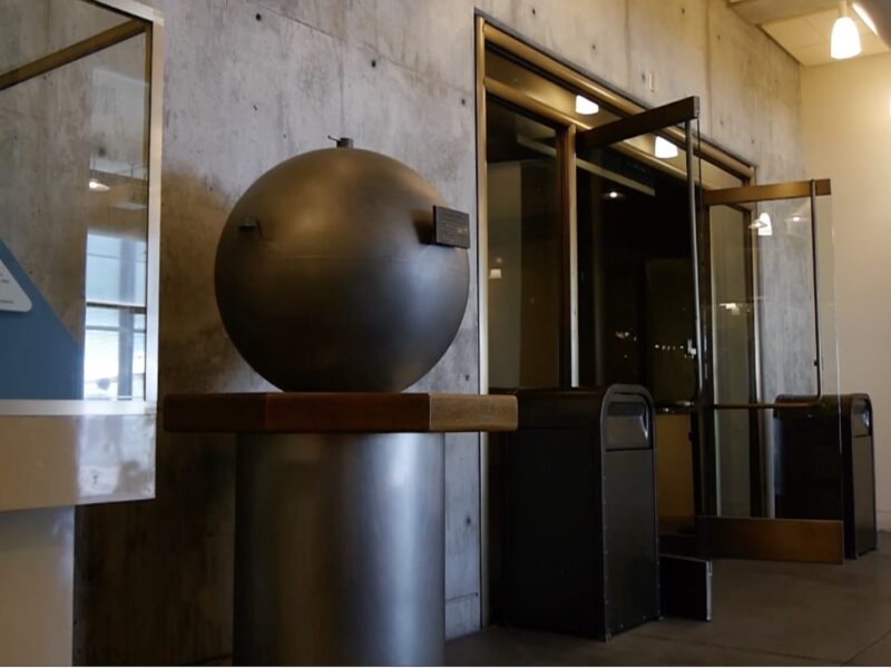 Large round bronze object on pedestal in the lobby of the Giffith Park Observatory. Object is a time capsule.