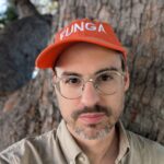 image of artist Ben Kinsley.  White male with read hat that reads "Funga".  Glasses on his face and a beard.